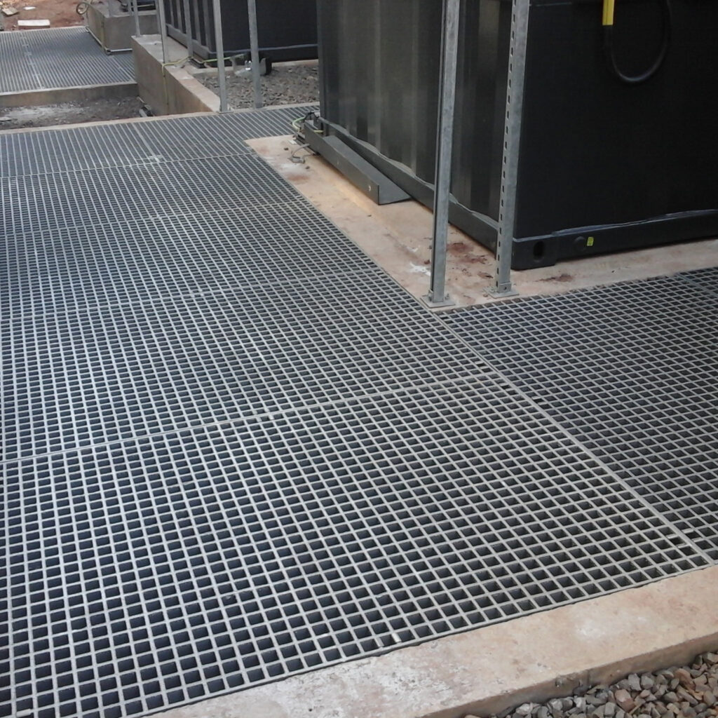 Grey QuartzGrip GRP Open Mesh Grating installed to cover drainage trenches